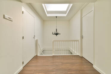White interior of narrow hall and staircase in contemporary cottage - ADSF41838