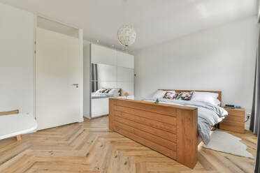 Comfortable bed next to a door and wooden floor - ADSF41856