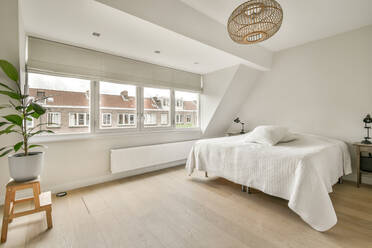 Comfortable bed next to a bright window and wooden floor - ADSF41876