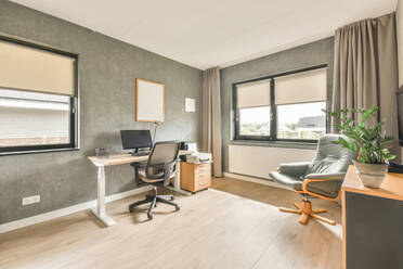 Interior with a desk by a bright window with gray walls - ADSF41893