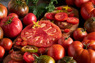 Hohe Winkel der geschnittenen Tomate zwischen reifen ganzen roten Tomaten mit Wassertropfen - ADSF41932