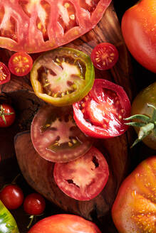 Hohe Winkel der geschnittenen Tomate zwischen reifen ganzen roten Tomaten mit Wassertropfen - ADSF41933