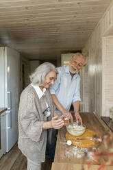 Älteres Ehepaar bereitet in der Küche Teig für Brot vor - LLUF00979