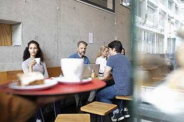 Männer und Frauen sitzen in einem Café und trinken Kaffee - NURF00002
