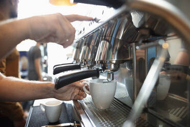 Hände eines Barista bei der Zubereitung von Kaffee mit einer Espressomaschine - NURF00016