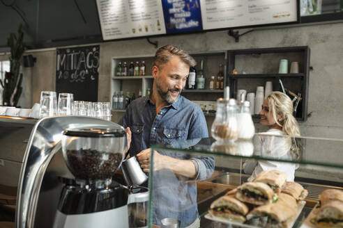 Barista dampft Milch an der Espressomaschine im Café - NURF00017