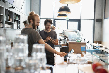 Glückliche Kollegen bei der Zusammenarbeit im Café - NURF00047