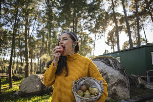Mature woman eating an apple - JCCMF08425