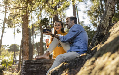 Mature couple holding bonsai outdoors - JCCMF08452