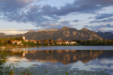 Deutschland, Bayern, Füssen, Blick auf den Hopfensee mit Bergdorf im Hintergrund - WIF04653