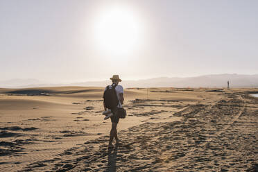 Man enjoying sunset walking on sand at beach - MMPF00534