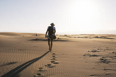 Man strolling on beach at sunset - MMPF00537