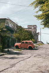 Kuba, Havanna, Pfirsichfarbener Oldtimer, geparkt auf der Straße im Viertel La Vibora - MMPF00549