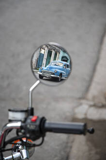 Blue vintage car reflecting in motorbike mirror - MMPF00552