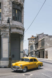 Kuba, Havanna, Gelber Oldtimer auf der Straße in Centro Habana - MMPF00553