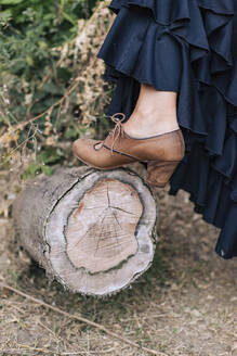Flamenco-Tänzerin mit Schuh hält Bein auf Baumstumpf - MMPF00564