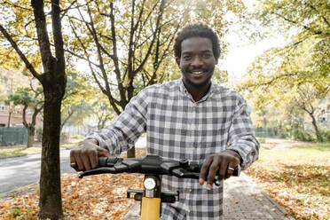 Mann auf dem Gehweg stehend mit Elektro-Scooter - OSF01195