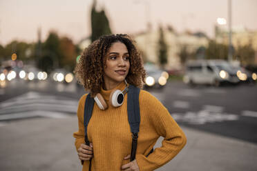 Beautiful young woman with backpack and wireless headphones - JCCMF08595