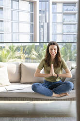 Happy woman mediating on sofa - SVKF00853