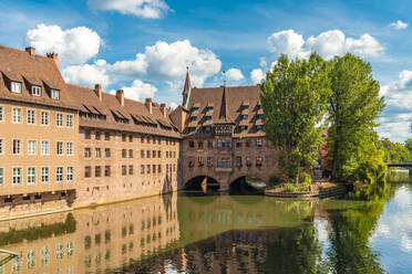 Germany, Bavaria, Nuremberg, Historic Holy Spirit Hospital on Pegnitz river - TAMF03644