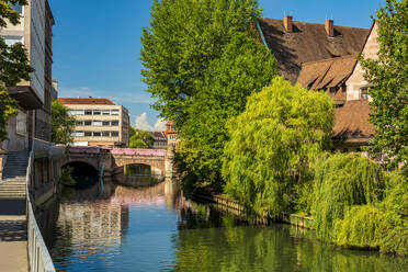 Deutschland, Bayern, Nürnberg, Grüne Bäume entlang der Pegnitz im Sommer mit Museumsbrücke im Hintergrund - TAMF03646