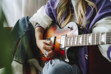 Hand of guitarist playing guitar in studio - MDOF00330