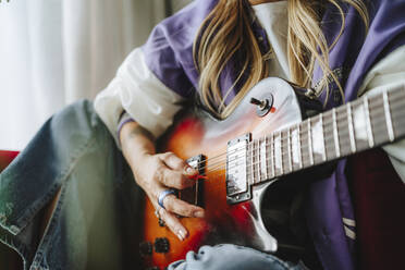 Hand of guitarist playing electric guitar in studio - MDOF00335