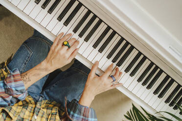 Hands of pianist practicing on piano in studio - MDOF00360