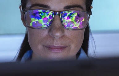 Reflection of molecular structure on scientist's eyeglasses in laboratory - ABRF01033