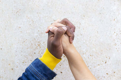 Man holding hand of woman in front of wall - JPTF01151