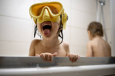 Junge mit Schwimmbrille beim Baden im Badezimmer - ANAF00642