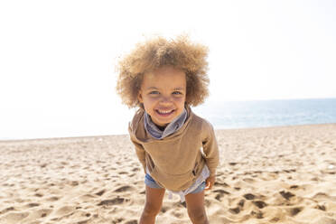 Glückliches süßes Mädchen mit Afrofrisur am Strand stehend - MEGF00276