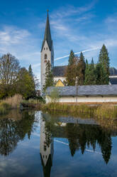 Deutschland, Bayern, Oberstdorf, Kirche St. Johannes Baptist spiegelt sich im See - MHF00683