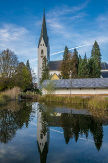 Germany, Bavaria, Oberstdorf, St. Johannes Baptist church reflecting in lake - MHF00683