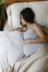 Pregnant mature woman sleeping on bed at home - TYF00506