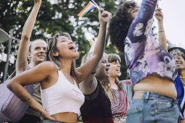 Fröhliche Freunde mit Regenbogenfahnen schreien bei der Parade für LGBTQIA-Rechte - MASF33566