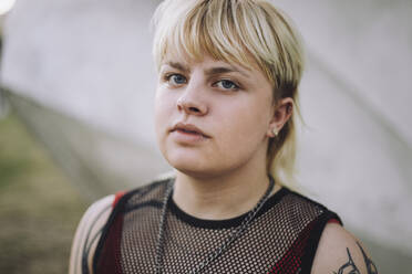 Porträt einer glücklichen jungen nicht-binären Person mit kurzen blonden Haaren - MASF33590
