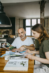 Geschäftsleute diskutieren bei der Arbeit im Studio über ein Foto - MASF33660