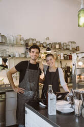 Portrait of happy male and female business owners standing together at cafe - MASF33747