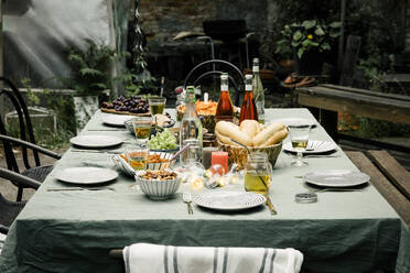 Essen und Trinken mit Tellern auf einem Esstisch im Hinterhof - MASF33852