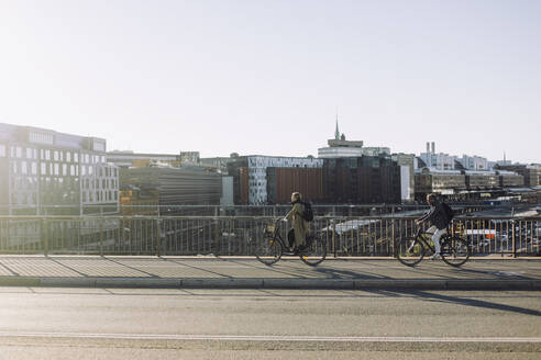 Männliche und weibliche Berufstätige, die mit dem Fahrrad auf der Straße pendeln - MASF33891