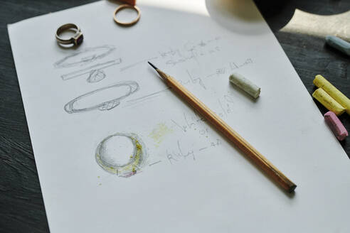 Pencil on paper with drawing of rings at workbench - DSHF00622