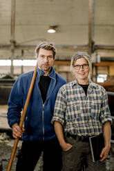 Smiling mature farmers standing together at cattle farm - MASF34015