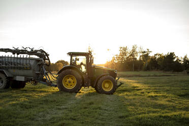 Traktor auf einem Feld bei Sonnenuntergang - MASF34061