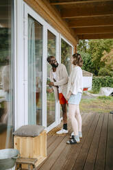 Glückliches Paar im Gespräch miteinander beim Betreten eines Hauses - MASF34088
