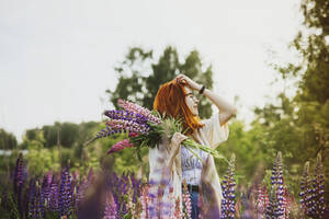 Teenager-Mädchen mit Lupinenblumenstrauß - IEF00279