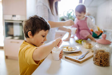 A mother of two little children preparing breakfast in kitchen at home. - HPIF03229