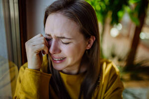 Eine Frau, die unter Depressionen leidet und zu Hause weint. - HPIF03285