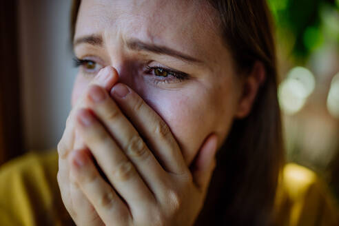 Eine Frau, die unter Depressionen leidet und zu Hause weint. - HPIF03286