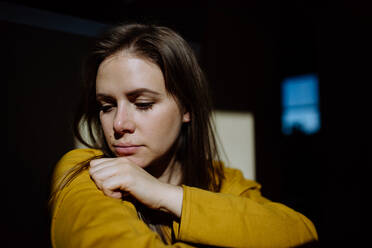 Junge Frau, die zu Hause unter Depressionen leidet, weint und aus dem Fenster schaut. - HPIF03296